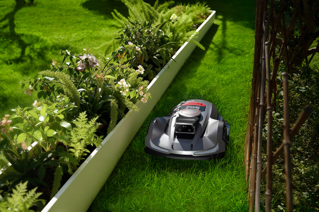 Sunseeker X7 Gen2 robot lawn mower mowing beside garden greenery