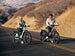 Two riders on Himiway D5 e-bikes on a canyon road
