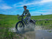 Rider on a Himiway D5 splashing through a puddle