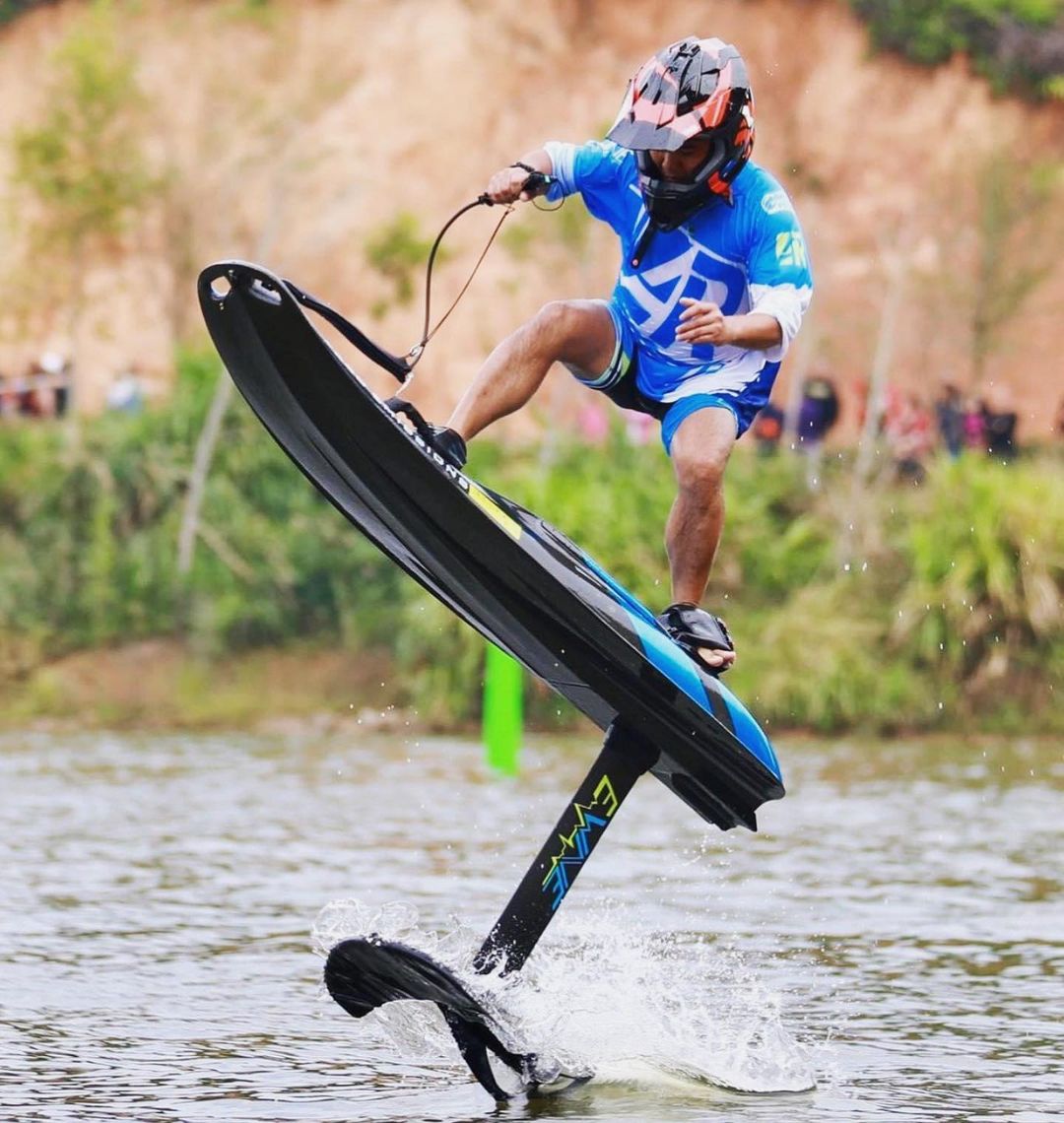 Rider on an EWAVE board with the hydrofoil attachment, foiling above the water
