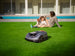 Family relaxing on the lawn while the Sunseeker X5 Gen2 mows