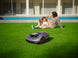 Family relaxing on the lawn while the Sunseeker X5 Gen2 mows